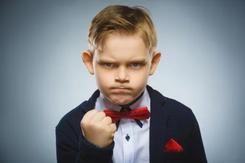 Angry boy isolated on gray background. He raised his fist to strike. Closeup Stock Photos