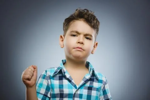 Angry boy isolated on gray background. He raised his fist to strike. Closeup Stock Photos