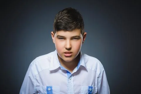 Angry boy isolated on gray background. Closeup Stock Photos