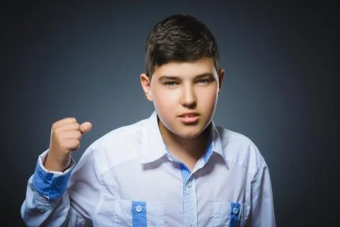 Angry boy isolated on gray background. He raised his fists to strike. Closeup Stock Photos
