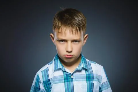 Angry boy isolated on gray background. Closeup Stock Photos