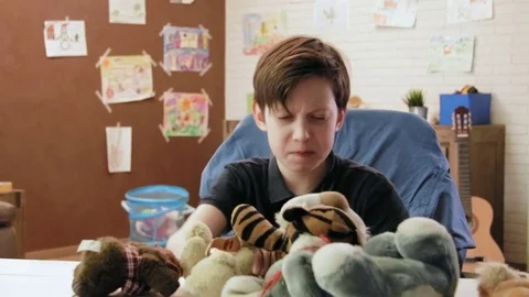 Angry boy making mess in his room throwing stuffed toys, shows his anger Vidéo 75747898