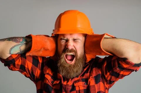 Angry builder man shouting covering ears with hands. Shouting construction .. Stock Photos
