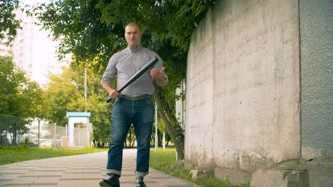 An angry bully with a bat in his hands Stockbeeldmateriaal 114499889