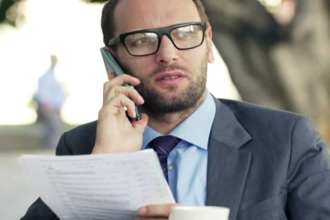 Angry businessman with documents talking by cellphone in cafe cityNTSC Stock Footage 47437771