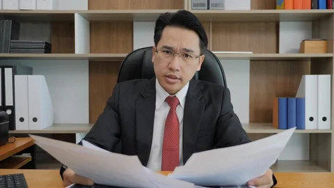 Angry businessman throwing papers into camera. Stock Footage 99853374