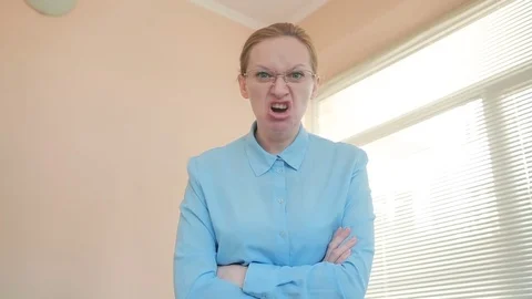 Angry businesswoman in the office, screaming at the camera close-up Stock Footage