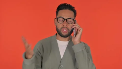 Angry Casual Hispanic Man Talking on Phone on Red Background, Portrait Video stock 295903154