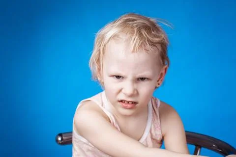 Angry child on a blue background Stock Photos