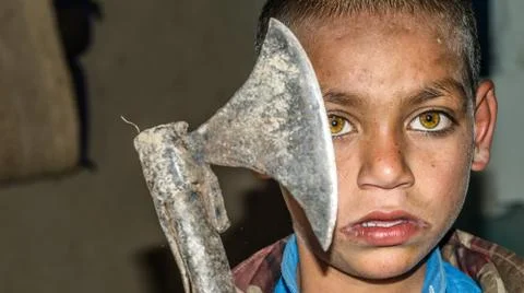 Angry child is holding a sharp axe Stock Photos
