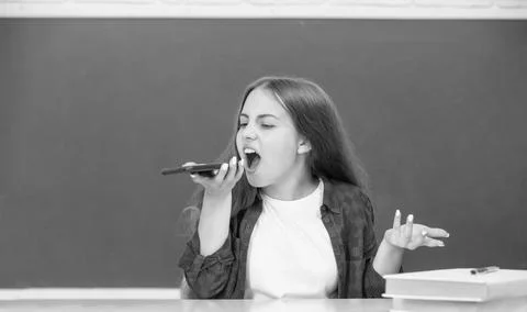 Angry child at school talking on phone on blackboard background, phone call Stock Photos