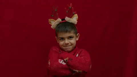 Angry child shaking his head as he dislikes his christmas gift. Grumpy naughty 動画素材 257838133