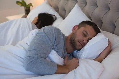 Angry couple avoiding each other in bedroom Foto stock