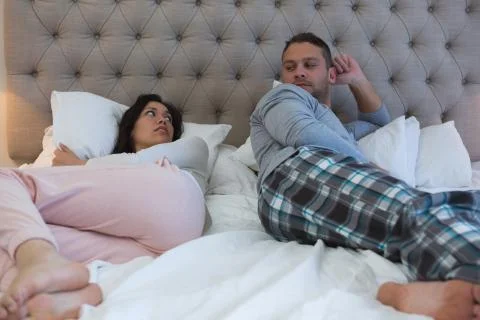 Angry couple avoiding each other in bedroom Stock Photos