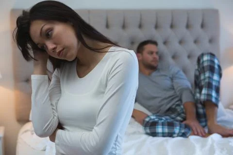 Angry couple avoiding each other in bedroom Stock Photos