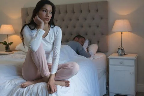 Angry couple avoiding each other in bedroom Foto stock
