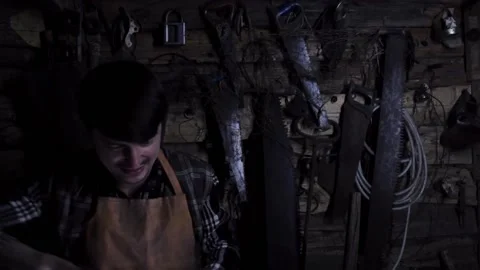 Angry crazy maniac sharpens rusty knives in an old house. copy space Stock Footage 137970741