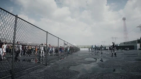 Angry crowd protesting AI near a data center,Robot carrying weapon, anti-AI Stock Footage 336346152