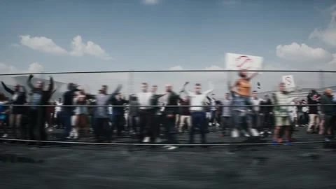 Angry crowd protesting AI near a data center,Robot carrying weapon, anti-AI Stock Footage 336346171