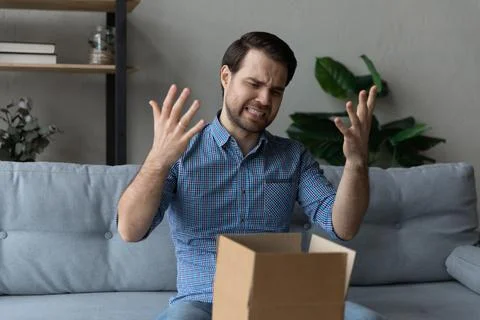 Angry dissatisfied customer receiving wrong parcel from internet store Stock Photos