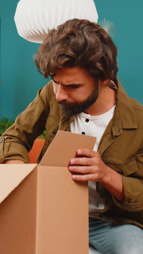 Angry dissatisfied shopper middle eastern man unpacking parcel feeling upset Stock Footage 320572189