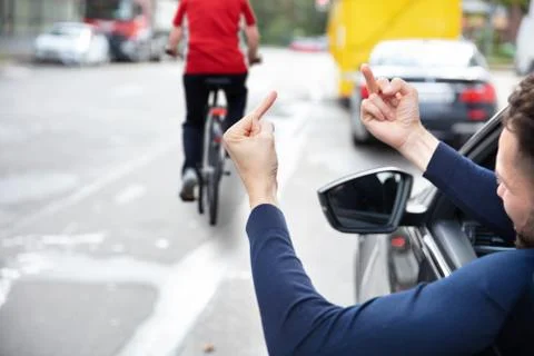 Angry Driver Showing Middle Finger To Woman Riding Bicycle Stock Photos