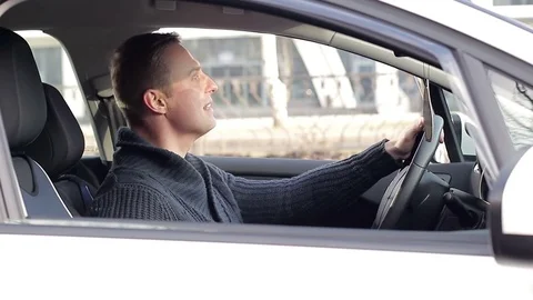 Angry driver in a traffic jam. He screams and gesticulates 库存影片 83492949