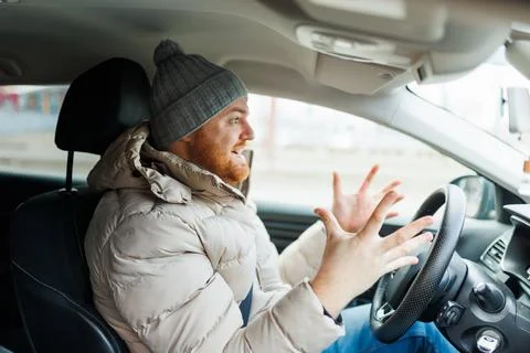 Angry driver in a traffic jam. He screams and Stock Photos