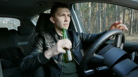 Angry drunk driver drinking alcohol while driving Stock Footage 107988931