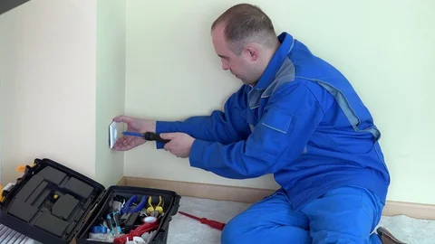 Angry electrician man with indicator test voltage on electric wall socket Stock Footage 72353456