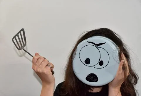 Angry emoji painted on the bottom of the kitchenware Stock Photos