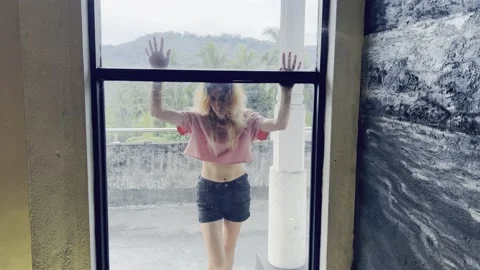 Angry ex girlfriend looking and punching window  Stock Footage 232396952