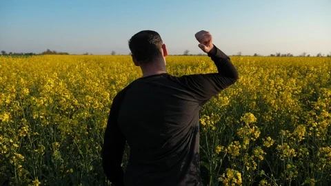 Angry farmer passing with protest through the colza field at sunset. Slow motion Stock Footage 107496959