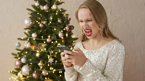 Angry festive woman typing on smart phone negative message Stock Footage 166323310
