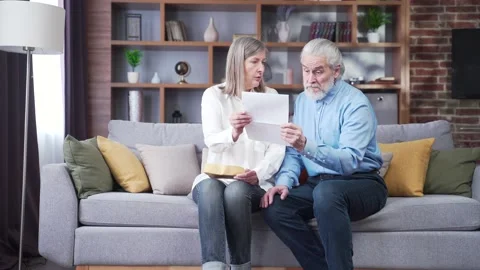 Angry frustrated document senior couple. Unhappy old family getting stressed.  Stock Footage