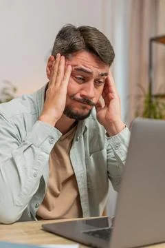 Angry furious man freelancer using laptop working at home office having nervous Stock Photos