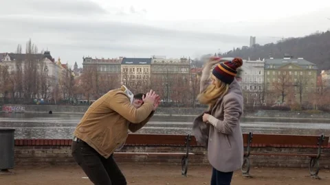 Angry girlfriend taking a bouquet of flowers and hitting a man with them Stock Footage 227065853