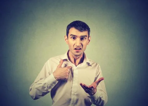 Angry guy pointing at himself asking you mean me, you talking to me Stock Photos