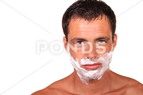 Angry handsome young man with a shaving foam Stock Photos