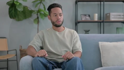 Angry Hispanic Man Feeling Stressed at Home Stockbeeldmateriaal 293257052