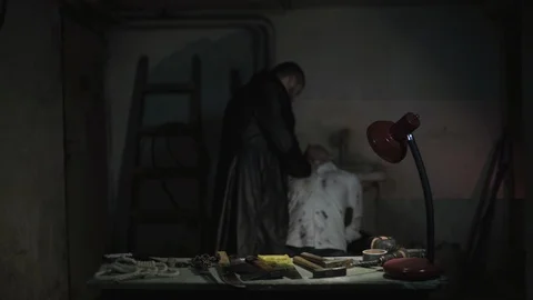 Angry killer putting knife blade on neck of victim with tied hands in basement. Video stock 86235997