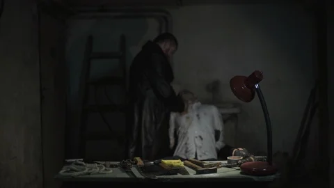 Angry killer putting knife under neck of victim with tied hands in dark basement Stock Footage 86236227