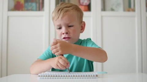 Angry little boy doing homework close up. Frowning kid in school. Angry boy.. Stock-Footage 340725567