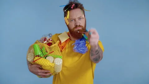 Angry looking man holding backage with trash, lookinfg at the camera. Stock Footage 146227786