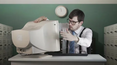 Angry man is beating old computer with hand in office. Video stock 160536983