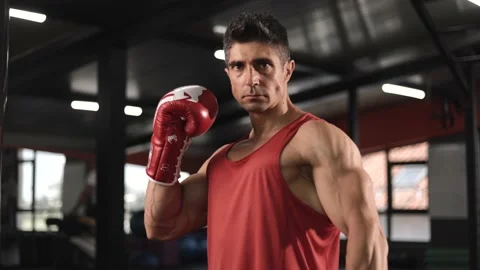 Angry man with boxing gloves looking ar the camera standing in the gym Stock Footage 201404993