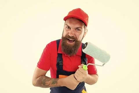 Angry man painter with paintroller in uniform. bearded man painter with Stock Photos