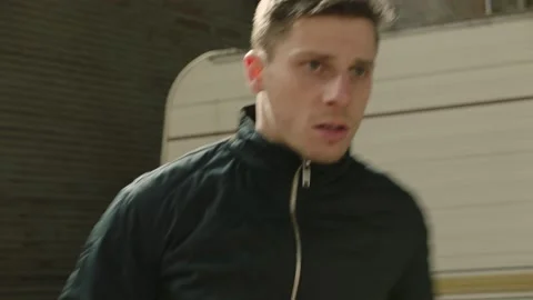 Angry man prepares to fight by punching the air and running out of frame, in fro Stock Footage 199463528