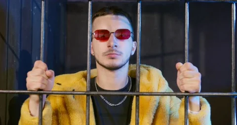 Angry man with red glasses in fur coat shakes bars in jail Video stock 162702166