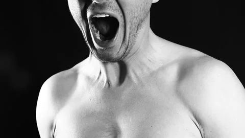 Angry man screams on a black background, aggression Video stock 99436465
